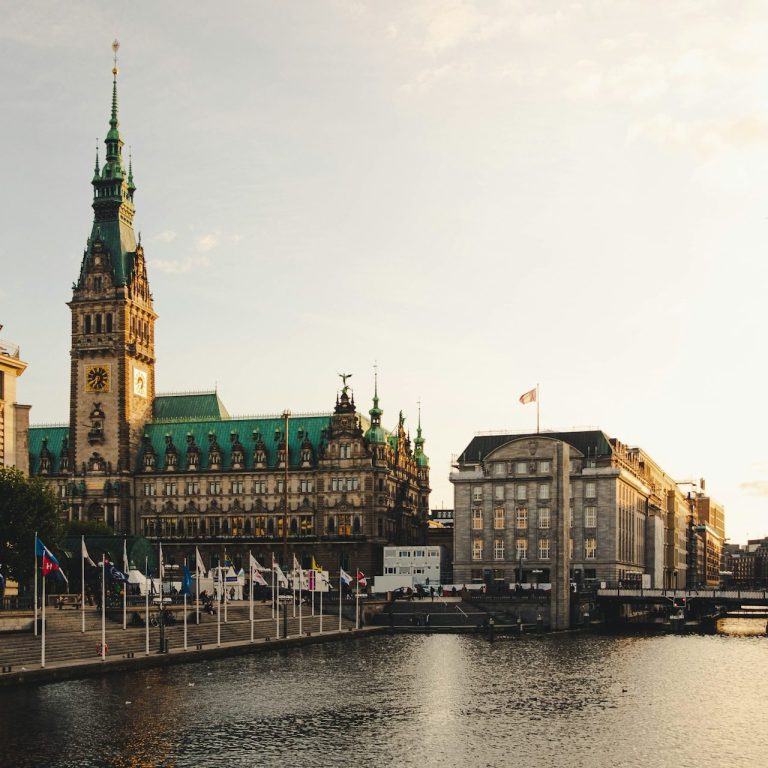 Das historische Hamburger Rathaus und der Binnenalster bei Sonnenuntergang.