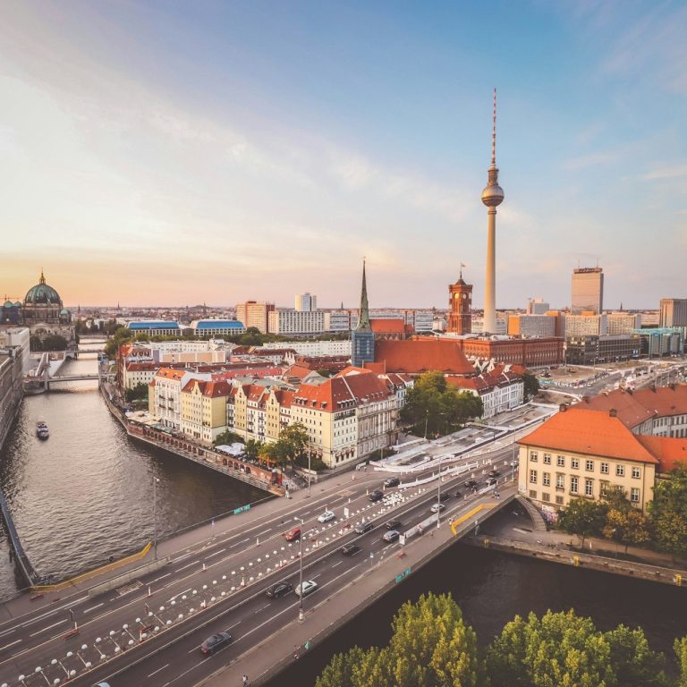 Blick auf Berlin mit Fernsehturm, Spree und Stadtarchitektur bei Sonnenuntergang.