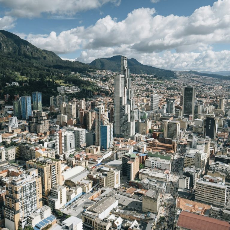 Stadtansicht von Bogotá mit modernen Gebäuden und Bergen im Hintergrund.